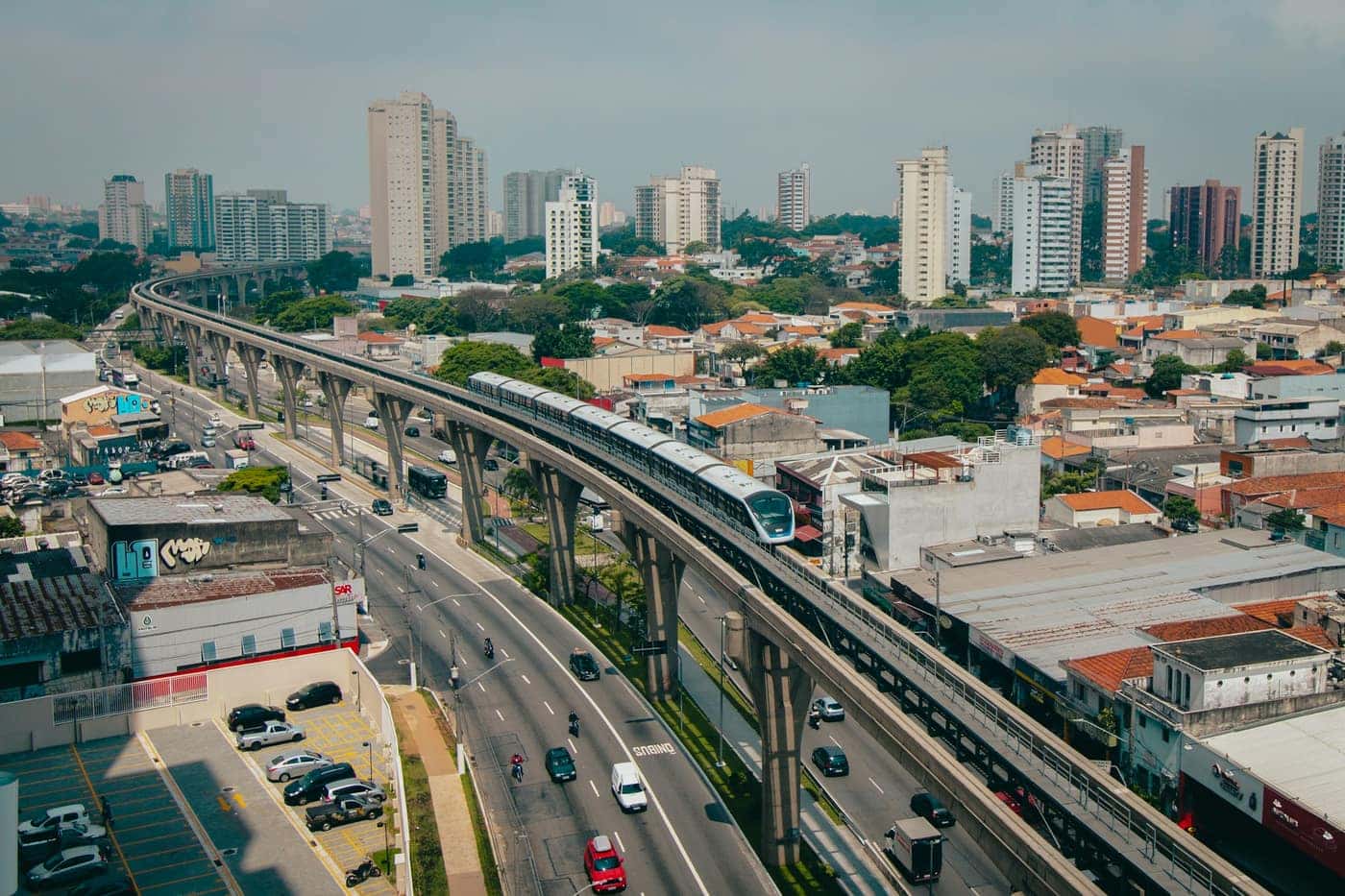 Vista aérea de São Paulo com um trem do metrô sobre elevado entre prédios e avenidas